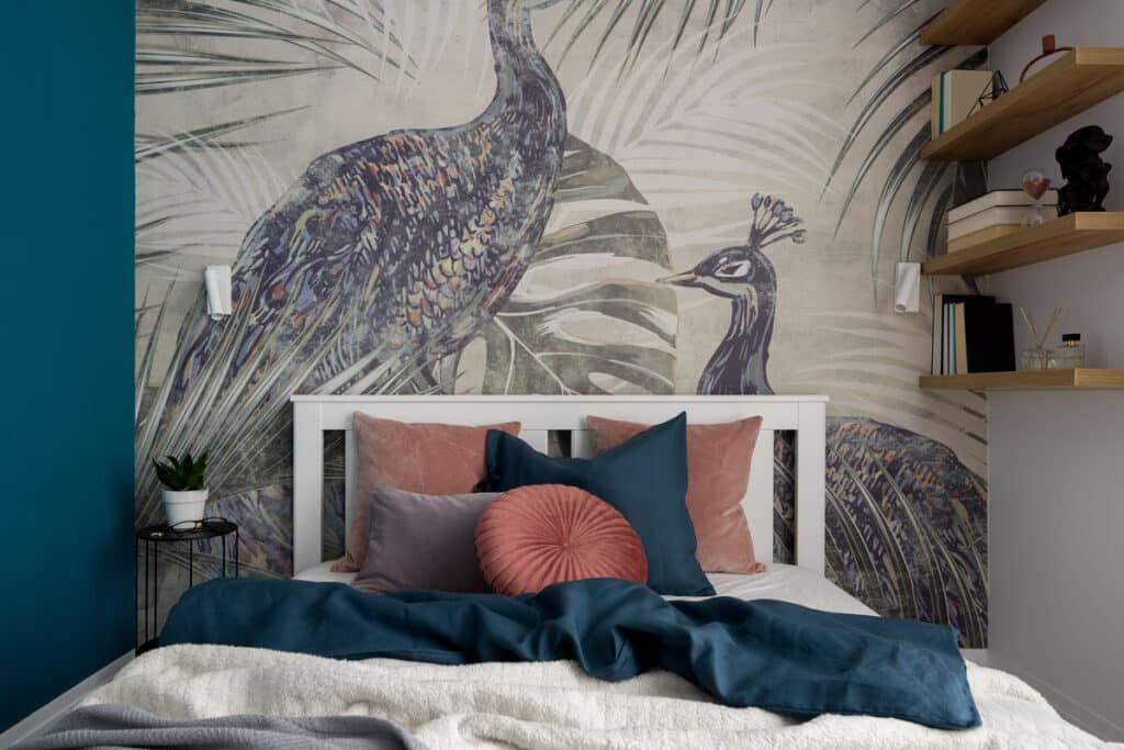 Chambre Paon : Déco Bohème Chic et Murale Tropicale Chambre moderne avec murale de paons et feuilles de palmier, literie bleu sarcelle et coussins roses.
